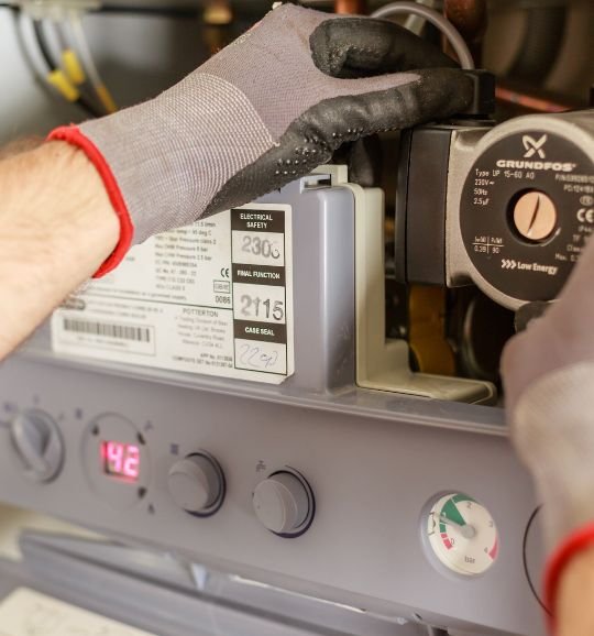 A technician wearing gloves services a gas furnace, showcasing commercial appliance repair in Chicago, IL.