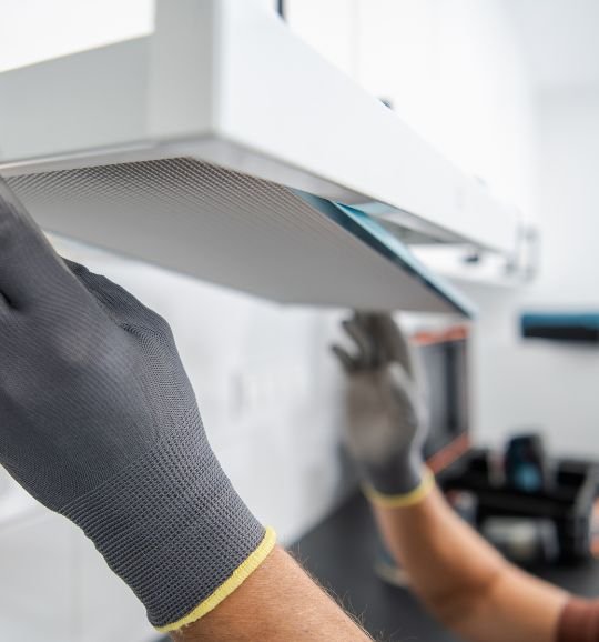 A gloved man holds a white plastic piece, symbolizing filters and parts for appliance repair in Chicago, IL.