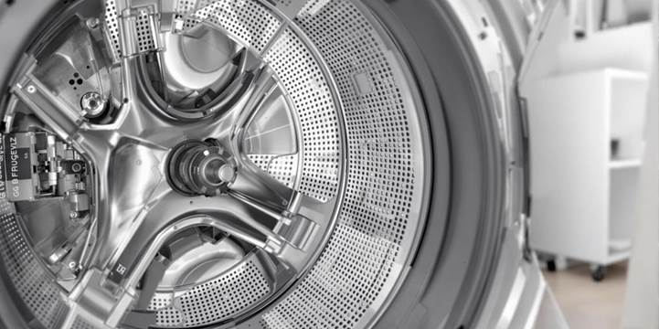 A close-up view of a washing machine situated in a well-lit room, showcasing its modern design and features.